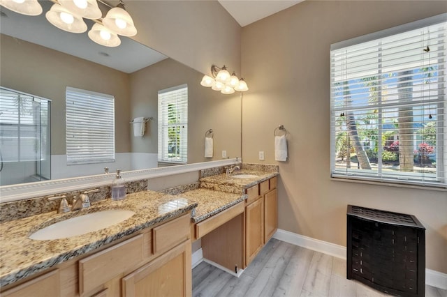 bathroom featuring a sink, heating unit, an inviting chandelier, and wood finished floors