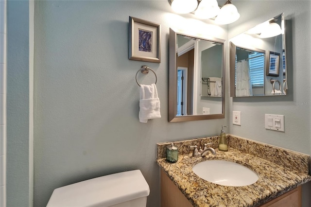 full bathroom featuring curtained shower, vanity, and toilet