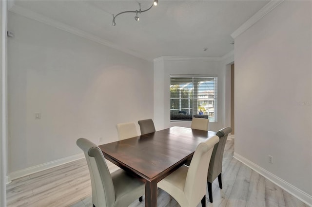 dining space featuring crown molding, baseboards, a chandelier, and light wood-style floors