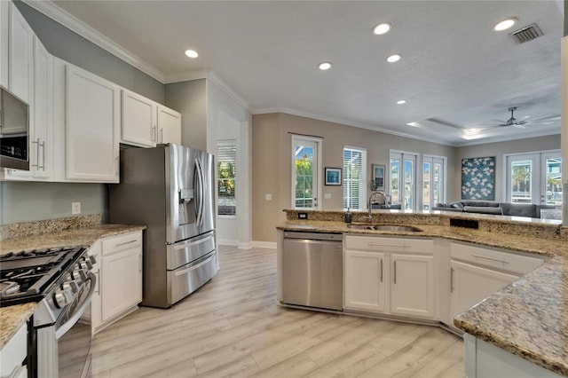 kitchen featuring crown molding, ceiling fan, visible vents, appliances with stainless steel finishes, and a sink
