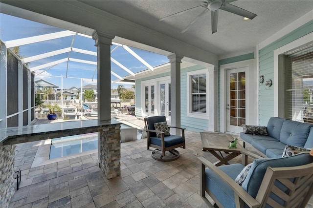 view of patio featuring an outdoor living space, a lanai, and a ceiling fan