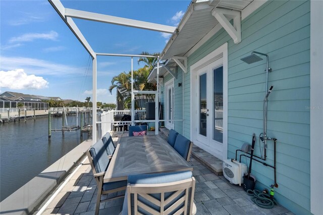 view of patio featuring a water view, a boat dock, and a lanai