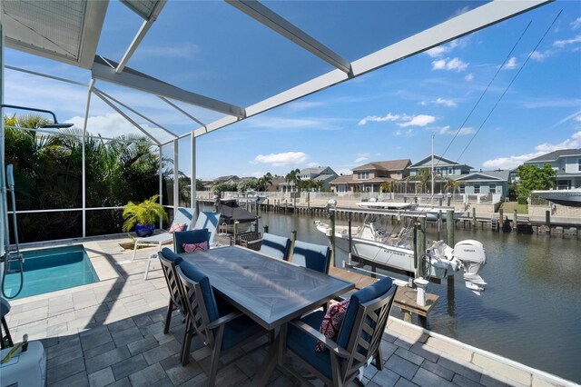 dock area with a patio area, a water view, boat lift, and a lanai