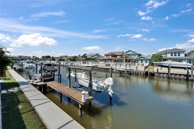 view of dock featuring a water view, a residential view, and boat lift