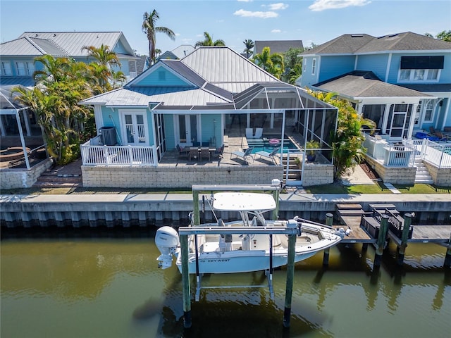 back of property featuring a patio, boat lift, french doors, a water view, and glass enclosure