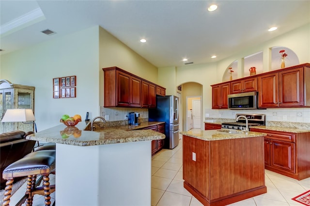 522 Planters Manor Way, Bradenton, FL 34212 - kitchen with appliances with stainless steel finishes, a peninsula, decorative backsplash, a breakfast bar, and recessed lighting