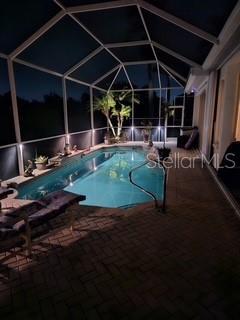 522 Planters Manor Way, Bradenton, FL 34212 - pool at night with a patio area, an outdoor pool, and a lanai