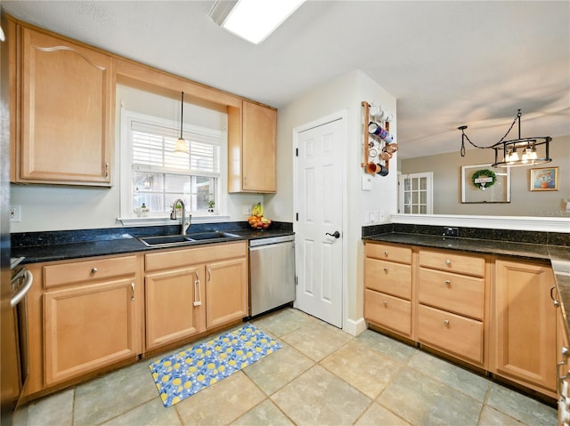 kitchen with dark countertops, light brown cabinets, stainless steel dishwasher, and a sink