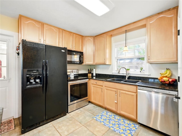 kitchen with dark countertops, a sink, black appliances, light brown cabinetry, and light tile patterned floors