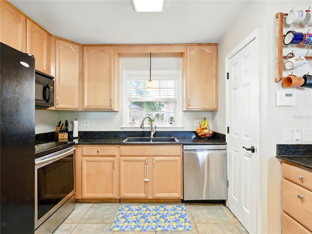 kitchen featuring light brown cabinetry, dark stone countertops, a sink, light tile patterned flooring, and black appliances