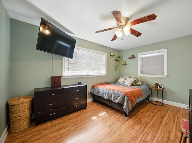 bedroom featuring baseboards, light wood-style floors, and ceiling fan