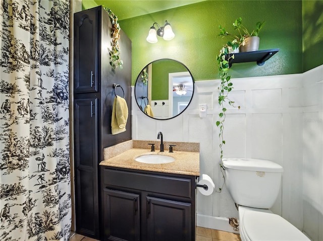 bathroom featuring a textured wall, vanity, tile patterned flooring, and toilet