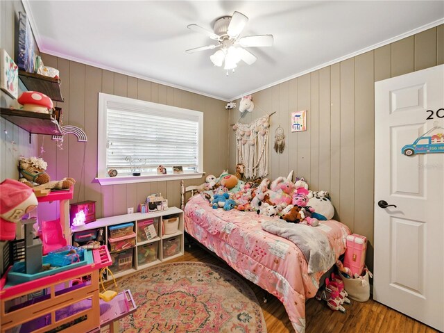 bedroom featuring wood finished floors, ceiling fan, and ornamental molding