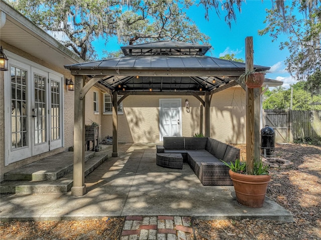 view of patio / terrace with an outdoor living space, french doors, fence, and a gazebo
