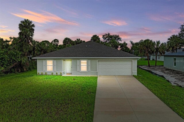 3879 E Price Blvd, North Port, FL 34288 - single story home featuring concrete driveway, roof with shingles, stucco siding, a front yard, and a garage