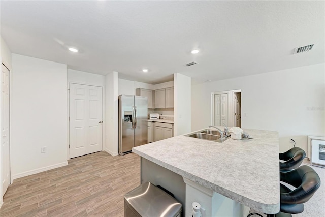 3879 E Price Blvd, North Port, FL 34288 - kitchen with stainless steel fridge with ice dispenser, a kitchen breakfast bar, visible vents, a sink, and light wood finished floors
