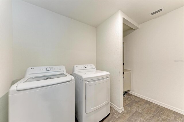 3879 E Price Blvd, North Port, FL 34288 - clothes washing area with light wood-style flooring, baseboards, visible vents, and washer and clothes dryer