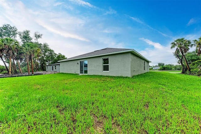 3879 E Price Blvd, North Port, FL 34288 - rear view of house featuring a lawn and stucco siding