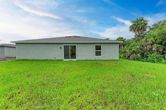 3879 E Price Blvd, North Port, FL 34288 - back of property featuring stucco siding and a lawn