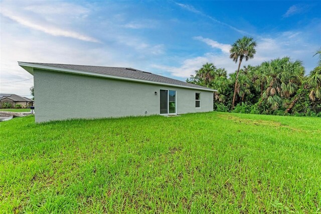3879 E Price Blvd, North Port, FL 34288 - rear view of property featuring a lawn and stucco siding