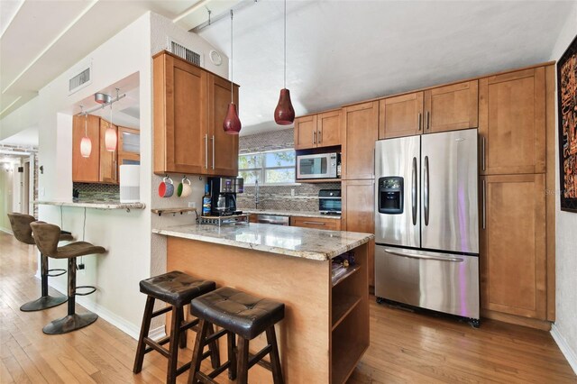 422 Dunedin Cir, Temple Terrace, FL 33617 - kitchen featuring stainless steel fridge, white microwave, hardwood / wood-style flooring, and visible vents