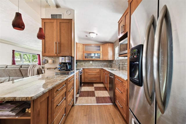 422 Dunedin Cir, Temple Terrace, FL 33617 - kitchen with wood-type flooring, a peninsula, brown cabinets, a sink, and stainless steel appliances