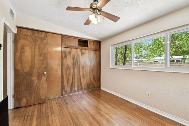 422 Dunedin Cir, Temple Terrace, FL 33617 - unfurnished bedroom featuring a closet, visible vents, baseboards, a textured ceiling, and hardwood / wood-style flooring