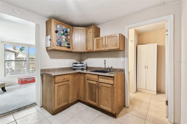 422 Dunedin Cir, Temple Terrace, FL 33617 - kitchen featuring brown cabinetry, a sink, and light tile patterned flooring