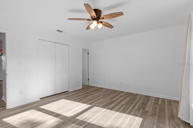 15118 Brushwood Dr, Tampa, FL 33624 - unfurnished bedroom featuring wood finished floors, a closet, baseboards, and a ceiling fan