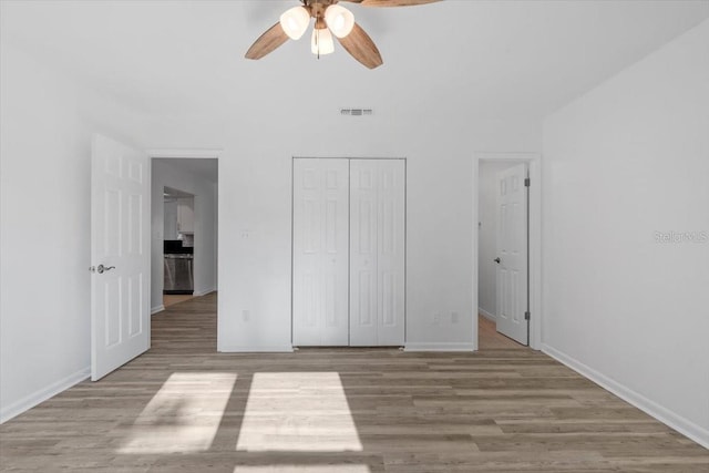 15118 Brushwood Dr, Tampa, FL 33624 - unfurnished bedroom with wood finished floors, baseboards, a closet, and a ceiling fan