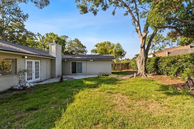 15118 Brushwood Dr, Tampa, FL 33624 - rear view of house featuring french doors, a chimney, a patio, and stucco siding