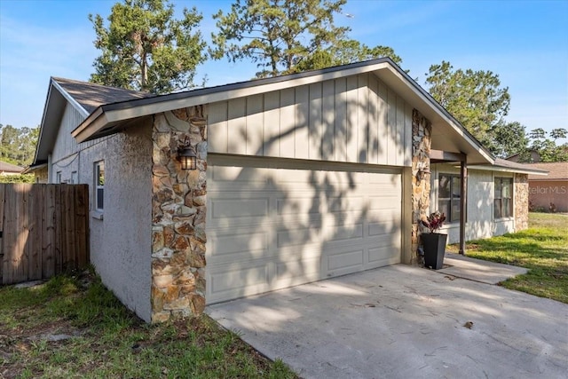 15118 Brushwood Dr, Tampa, FL 33624 - view of property exterior featuring stone siding, a garage, and concrete driveway