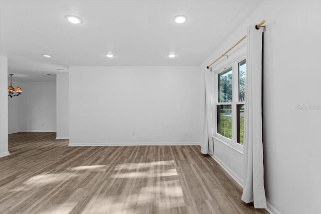 15118 Brushwood Dr, Tampa, FL 33624 - unfurnished room featuring baseboards, wood finished floors, a chandelier, and recessed lighting