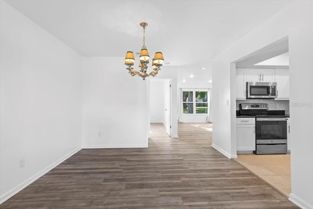 15118 Brushwood Dr, Tampa, FL 33624 - unfurnished dining area with a chandelier, wood finished floors, and baseboards