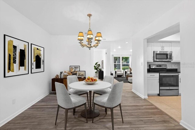 15118 Brushwood Dr, Tampa, FL 33624 - dining space with a chandelier, light wood finished floors, and baseboards