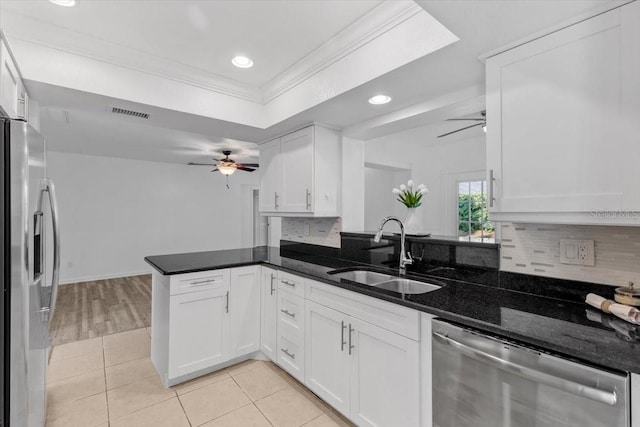 15118 Brushwood Dr, Tampa, FL 33624 - kitchen with appliances with stainless steel finishes, a sink, a ceiling fan, crown molding, and decorative backsplash