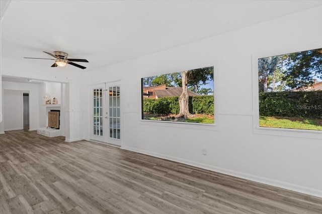 15118 Brushwood Dr, Tampa, FL 33624 - unfurnished living room with a fireplace with raised hearth, light wood finished floors, and baseboards