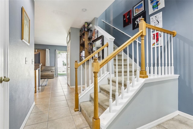 stairway featuring tile patterned floors and baseboards
