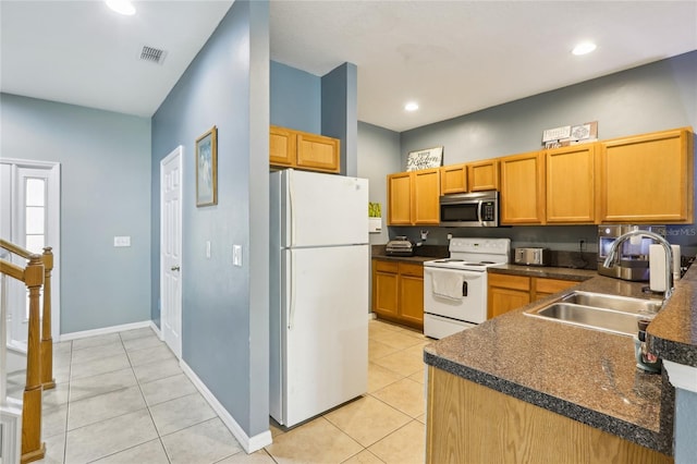 kitchen featuring white appliances, a sink, dark countertops, light tile patterned flooring, and recessed lighting