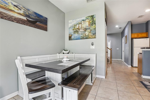 dining room with light tile patterned floors, recessed lighting, baseboards, and breakfast area