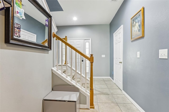 staircase featuring tile patterned flooring and baseboards