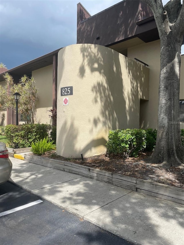 825 S Village Dr N Unit 201, Saint Petersburg, FL 33716 - view of home's exterior featuring stucco siding and uncovered parking