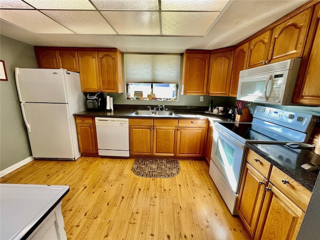 825 S Village Dr N Unit 201, Saint Petersburg, FL 33716 - kitchen featuring white appliances, a sink, brown cabinetry, light wood-type flooring, and a drop ceiling