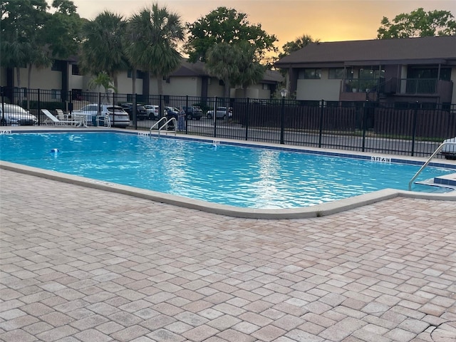 825 S Village Dr N Unit 201, Saint Petersburg, FL 33716 - pool at dusk featuring fence, a community pool, and a patio