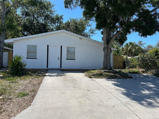 view of front of house with concrete driveway and fence