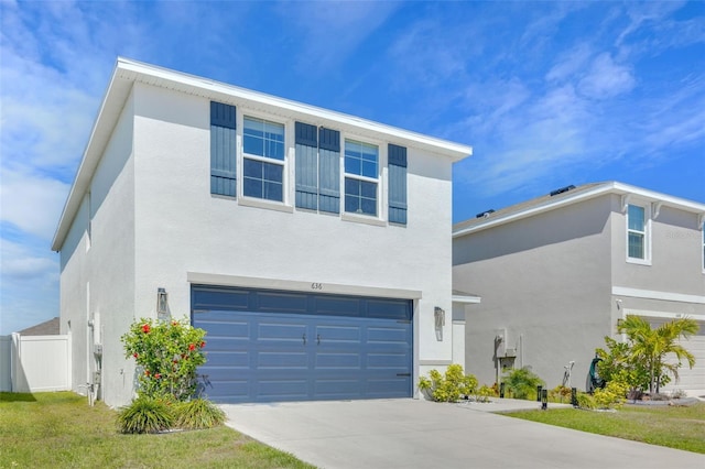contemporary home with a garage, driveway, stucco siding, and fence