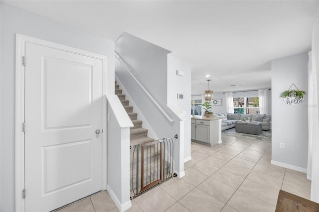 staircase featuring tile patterned floors and baseboards