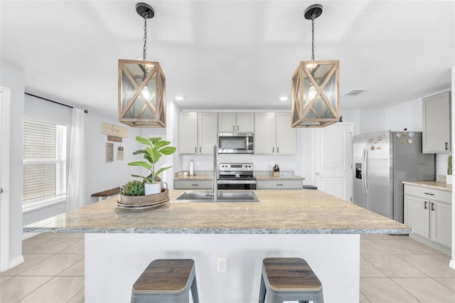 kitchen with light tile patterned flooring, stainless steel appliances, and light countertops
