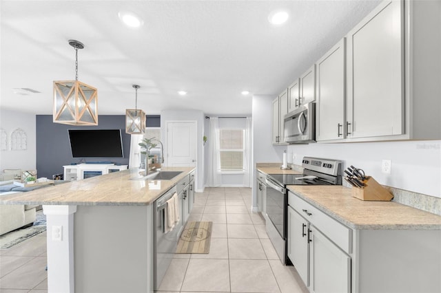 kitchen featuring stainless steel appliances, a sink, a center island with sink, open floor plan, and light tile patterned floors
