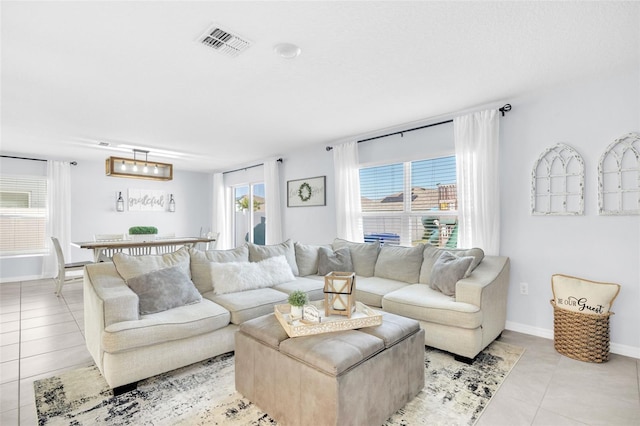 living area with visible vents, baseboards, and light tile patterned floors